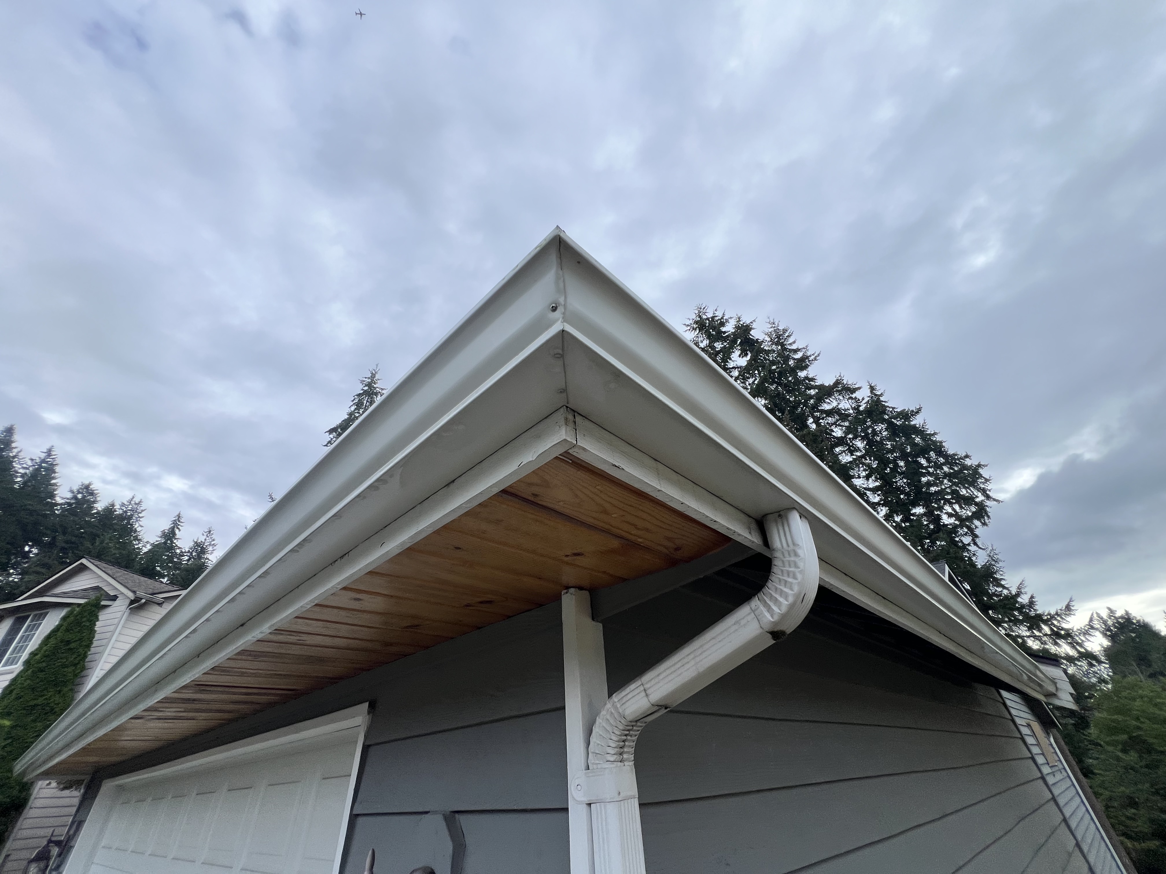 The photo shows a clean white gutter from the outside. This photo shows the outside gutter cleaning job from the exterior cleaning service from Bekman LLC